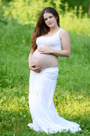The pregnant woman in summer on grassの写真素材