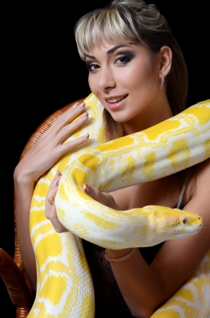 The beautiful woman with big yellow snakeの写真素材