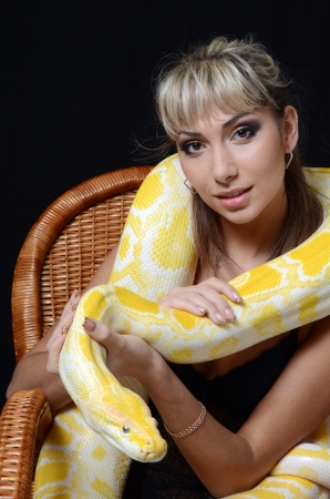 The beautiful woman with big yellow snakeの写真素材