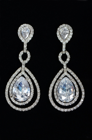 Silver earrings with jewels on the blackの写真素材