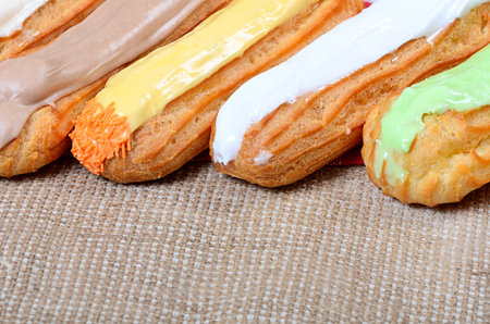Eclair with a cream on a plate close up