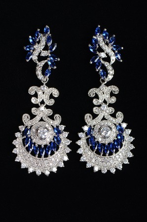 Silver earrings with jewels on the blackの写真素材