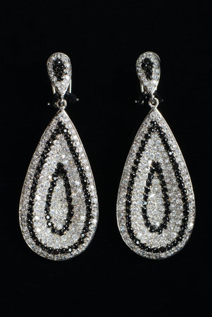 Silver earrings with jewels on the blackの写真素材