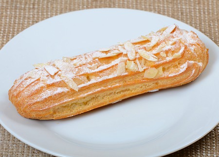 Eclair with a cream on a plate close upの写真素材