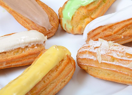 Eclair with a cream on a plate close upの写真素材