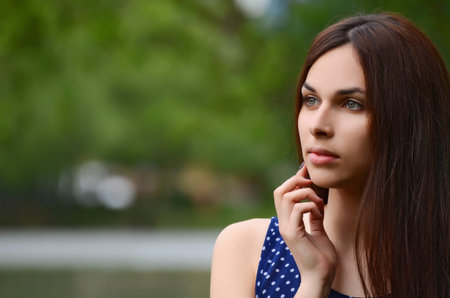 The beautiful young girl in summer park