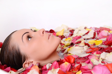 Beautiful female in bath with rose petal. Body care.の写真素材