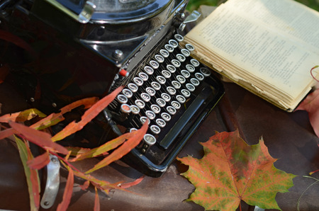 Romantic autumn still life with books, plaid, vintage suitcase, old typewriter  and leavesの写真素材