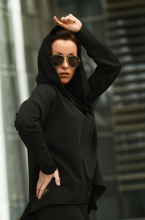 Fashion cool girl in sunglasses in urban background, fashion look. Fashion pretty  woman in rock black styleの写真素材