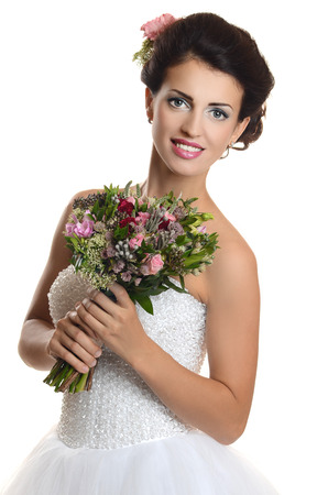 Studio portrait of a young beautiful bride with a wedding bouquetの写真素材