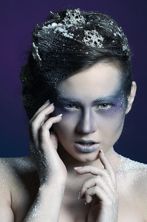 Portrait of a beautiful girl in the frost on his face on a blue  backgroundの写真素材