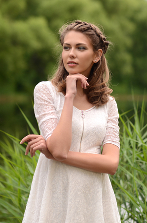 Beautiful natural young blonde smiling woman on field keep in hand yellow flowersの写真素材