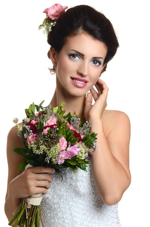 Studio portrait of a young beautiful bride with a wedding bouquetの写真素材