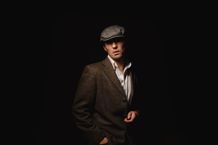 A man in a classic jacket and cap. A man in the dark.の写真素材