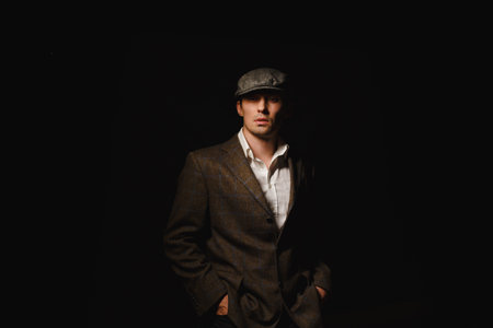 A man in a classic jacket and cap. A man in the dark.の写真素材