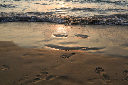A smile on the sea sand from the footprints of the sunsetの写真素材