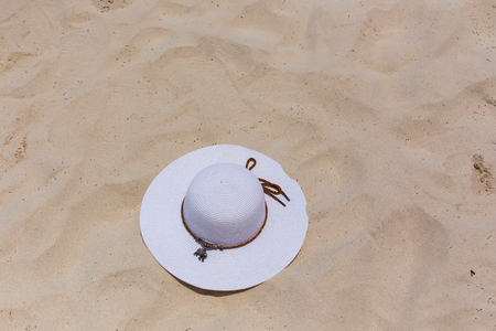 A white female hat lies on the sand on the seashore. Island Coral.の写真素材