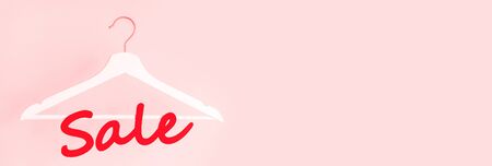 Sale concept. ? lothes hanger and the word sale on a pink background.の写真素材