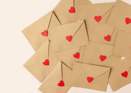 Valentines day background. Envelops with red hearts decor on a table. Top view.の写真素材