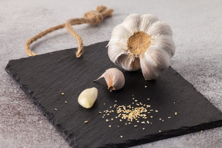 fresh whole garlic, garlic cloves and garlic granules on black board