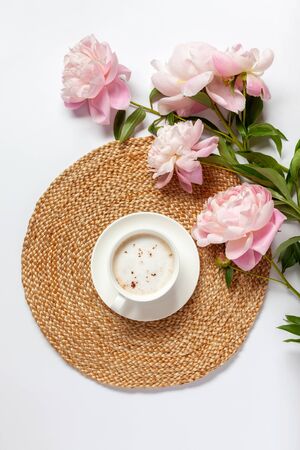 Cup of coffee and peony flowers on the table. Top view. Flat lay.の写真素材