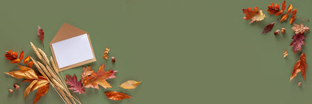 Autumn composition. Leaves and envelope on a green background. Web banner. Copy space