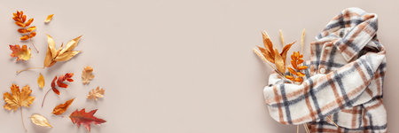 Autumn composition. Leaves and coat on a beige background. Web banner. Copy space