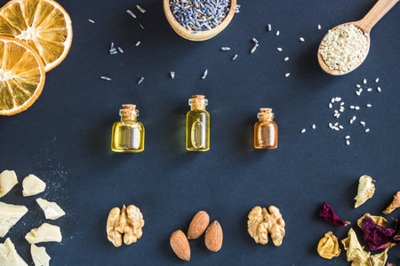 Cosmetic and medicinal oil of walnut and almond, herbs and other ingredients on a black background