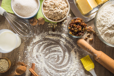 Composition of baking ingredients for oatmeal cookies with walnuts, sesame seeds and raisinsの写真素材