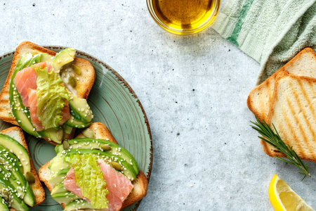 Toast with avocado and salmon fish on the table close-up.