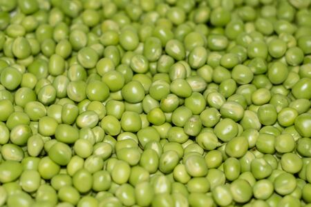 Background of young juicy green peeled peas moundの写真素材