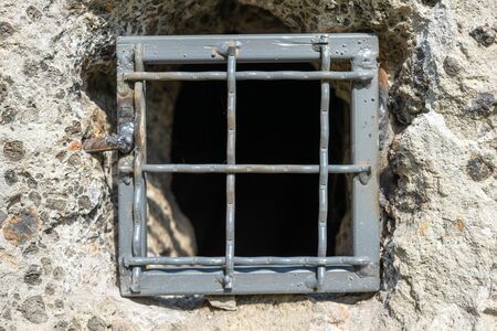 in a gray concrete wall the lattice is made of metalの写真素材