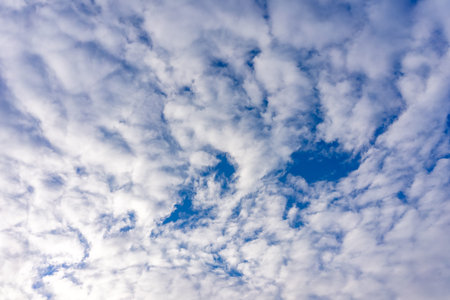 White cumulus clouds in a bright blue sky.