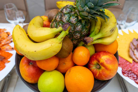 Fresh vegetables and fruits on a white plate. Fruit tray on a plate in a restaurant.の写真素材