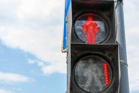Red traffic light for pedestrians on the background of the blue sky. Red number 1 at the traffic light. Place for writing, copy space.の写真素材