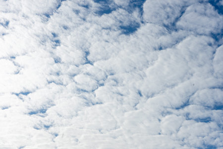 White cumulus clouds on the background of the blue sky.