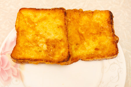 Golden brown French toast on a flower plate.の写真素材