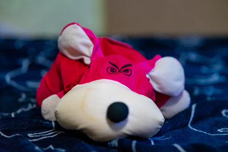 Plush red fox toy with a sly expression on a patterned blanketの写真素材