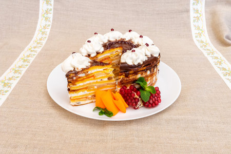 A beautifully presented cake with multiple layers of cream and fruity flavors sits on a white plate....