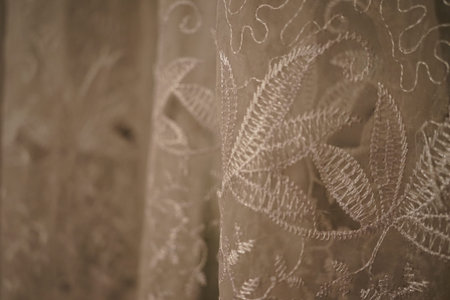 Delicate lace curtains feature intricate floral patterns, highlighting the fine craftsmanship...