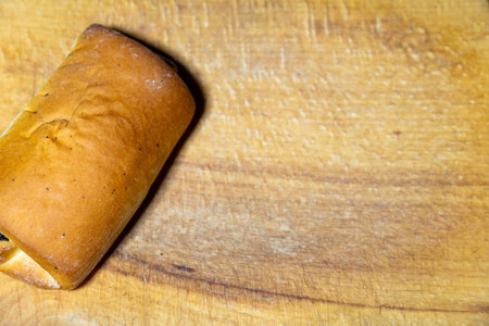 Freshly baked bread roll on wooden cutting board