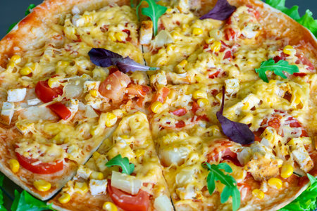 A colorful pizza is displayed on a green lettuce bed. Topped with chicken, corn, tomatoes, and cheese, it showcases vibrant colors and a delectable appearance, inviting anyone to taste.の写真素材