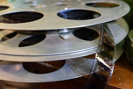 Vintage film reels stacked on a wooden surface in an old workshopの写真素材