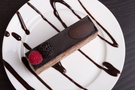 A top down view of a slice of chocolate cake on a white plate.