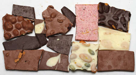 Pieces of chocolate sit on a white backdrop.の写真素材