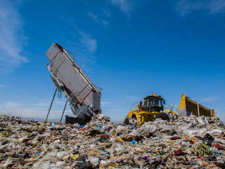 Modern  hydraulic disposer empties a complete trailer, while bulldozer manages landfill.