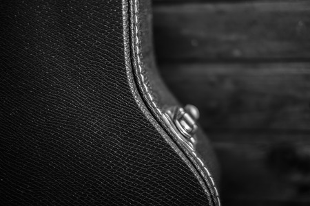 Black guitar case with wooden backgroundの写真素材
