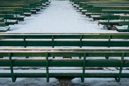 Green snowy benches in winter parkの写真素材