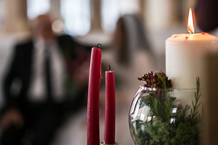 Wedding candles with an abstract blurred background with bride and groom.の写真素材
