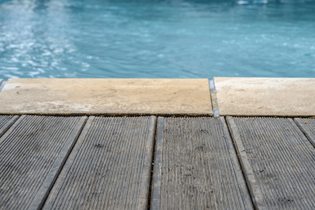 Swimming pool and wooden deck and bricks for the backgroundの写真素材